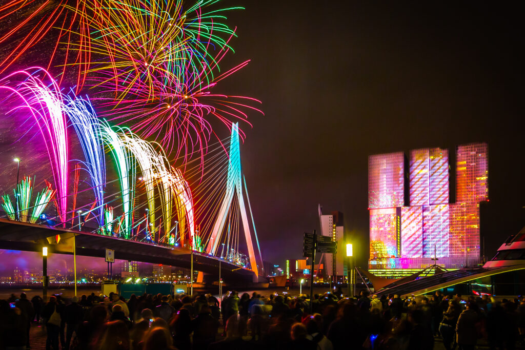 Nationale vuurwerk show in Rotterdam met een kleurrijk beeld van de Erasmusbrug en kop van zuid met vuurwerk.